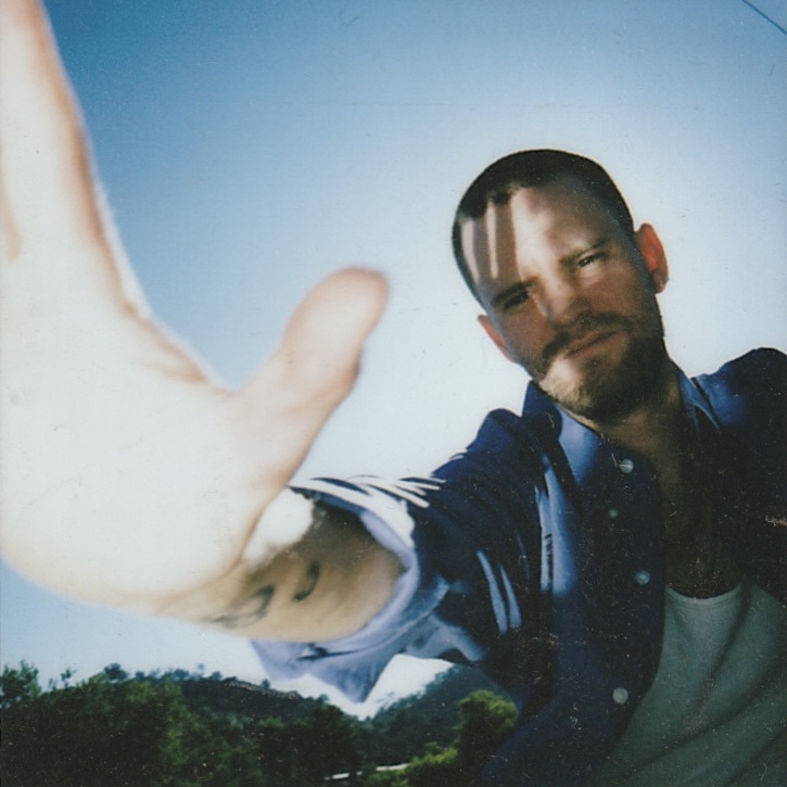 Atticus Reynolds — looking up at a radio tower against a blue sky